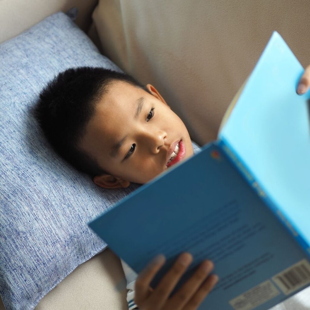 Stamina: a child reading a book on the couch