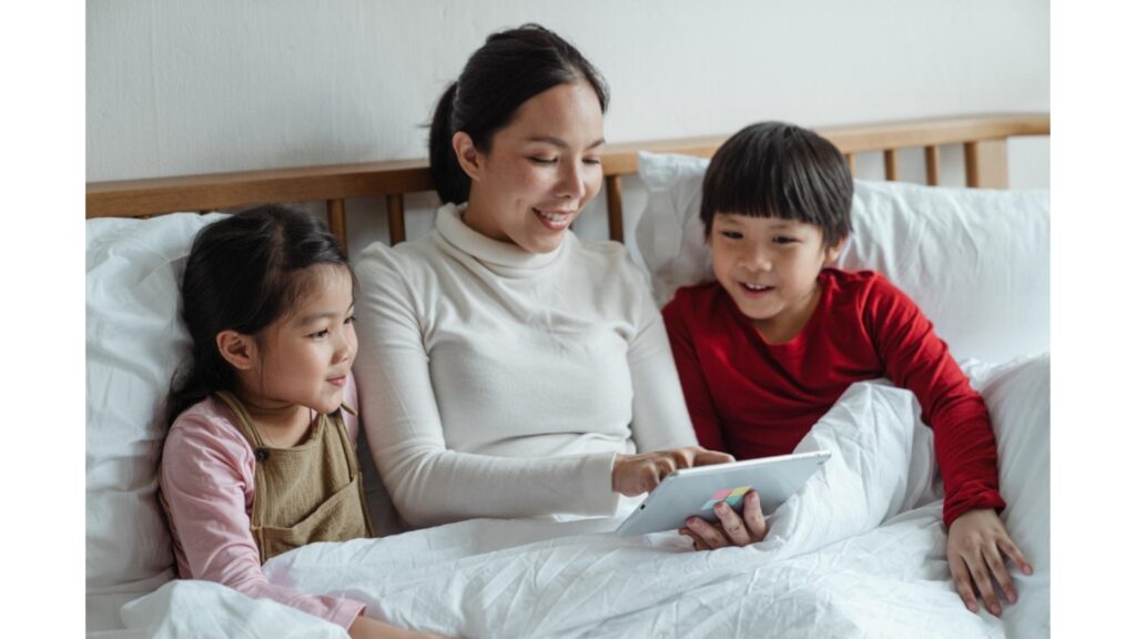 A mother reading to her two children in bed